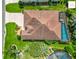 Aerial view of home showcasing the roof, driveway, landscaping, and a screened-in pool at 2994 Adrienne Way, The Villages, FL 32163