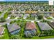 Extensive aerial view showcasing a planned community featuring lush landscaping, houses, and roads at 2994 Adrienne Way, The Villages, FL 32163