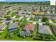 Aerial view of a neighborhood featuring lush landscaping, houses, and a community street at 2994 Adrienne Way, The Villages, FL 32163