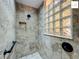 Tiled shower with glass block window and built-in niche at 2994 Adrienne Way, The Villages, FL 32163