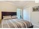Bedroom featuring a queen-sized bed with striped bedding, framed art, and a window with blinds at 2994 Adrienne Way, The Villages, FL 32163