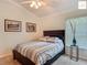 Bedroom featuring a queen-sized bed with striped bedding, framed art, and a window with blinds at 2994 Adrienne Way, The Villages, FL 32163