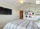 Bedroom with built-in shelving, ceiling fan, and mounted TV at 2994 Adrienne Way, The Villages, FL 32163