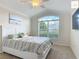 Bright bedroom featuring a large window, ceiling fan, and a comfortable bed at 2994 Adrienne Way, The Villages, FL 32163