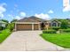 Stunning single Gathering home featuring a spacious three car garage, beautiful landscaping, and a decorative driveway at 2994 Adrienne Way, The Villages, FL 32163