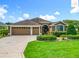 Charming exterior view of home, showcasing the three-car garage, manicured lawn, and inviting curb appeal at 2994 Adrienne Way, The Villages, FL 32163