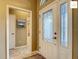 Foyer with a decorative front door and view into the hallway and adjacent bathroom at 2994 Adrienne Way, The Villages, FL 32163