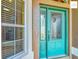 Close-up of the teal front door with glass panes and textured exterior wall at 2994 Adrienne Way, The Villages, FL 32163