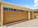 Spacious two-car garage with paneled doors and decorative windows on a sunny day at 2994 Adrienne Way, The Villages, FL 32163