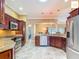 Open kitchen with stainless steel appliances, granite countertops, and tiled floors at 2994 Adrienne Way, The Villages, FL 32163