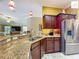 Bright kitchen features bar seating, stainless appliances, granite countertops, and warm pendant lights at 2994 Adrienne Way, The Villages, FL 32163