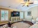 Bright living room showcases large TV, plantation shutters, and neutral decor at 2994 Adrienne Way, The Villages, FL 32163