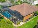 Aerial view of a home with a screened-in pool, patio furniture, and well-maintained landscaping at 2994 Adrienne Way, The Villages, FL 32163