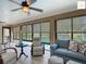 Bright sunroom overlooking the pool, featuring travertine floors and comfortable seating at 2994 Adrienne Way, The Villages, FL 32163