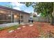 Enclosed backyard featuring a screened patio and mulch groundcover at 3015 Casselwood St, Winter Park, FL 32792
