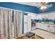 Charming kitchen featuring white cabinets, stainless steel appliances, and an adjacent laundry area at 3015 Casselwood St, Winter Park, FL 32792