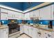 Well-lit kitchen features white cabinets, granite countertops, and stainless-steel appliances at 3015 Casselwood St, Winter Park, FL 32792