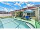 Backyard with a screened-in pool, patio furniture, and an umbrella for shade, perfect for outdoor living at 3016 Bloomsbury Dr, Kissimmee, FL 34747