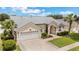 An aerial shot shows a home with a well-maintained lawn and landscaping, plus a two-car garage at 3128 Ibis Hill St, Clermont, FL 34714