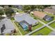 Aerial view of a home featuring a screened-in pool, fenced-in yard, and beautifully landscaped grounds at 3128 Ibis Hill St, Clermont, FL 34714