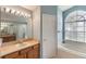 Ensuite bathroom features a soaking tub, glass shower, and a large mirror with vanity lights at 3128 Ibis Hill St, Clermont, FL 34714