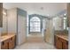 Ensuite bathroom boasts dual vanities, soaking tub, glass shower and vaulted ceilings at 3128 Ibis Hill St, Clermont, FL 34714