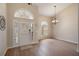 Welcoming entryway with hardwood floors, a modern chandelier, and ample natural light streaming through arched windows at 3128 Ibis Hill St, Clermont, FL 34714