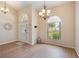 Inviting entryway with hardwood floors, arched windows, a chandelier, and neutral wall color, creating a warm ambiance at 3128 Ibis Hill St, Clermont, FL 34714