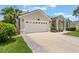 Spacious two-car garage with decorative windows and a paved driveway, enhanced by lush landscaping at 3128 Ibis Hill St, Clermont, FL 34714