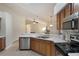 Updated kitchen offers stainless steel appliances, light countertops, wooden cabinets, and tile flooring at 3128 Ibis Hill St, Clermont, FL 34714