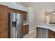 Kitchen with wooden cabinets, stainless steel refrigerator, dishwasher, tile floors, and light countertops at 3128 Ibis Hill St, Clermont, FL 34714