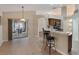 Open kitchen featuring tile floors, wooden cabinets, stainless steel appliances, breakfast bar, and access to a screened lanai at 3128 Ibis Hill St, Clermont, FL 34714