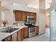 Well-lit kitchen features wooden cabinets, tile floors, stainless steel appliances, and easy access to other rooms at 3128 Ibis Hill St, Clermont, FL 34714