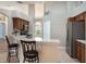 Kitchen with dark wood cabinets, stainless steel appliances, and a breakfast bar, blending style and functionality at 3128 Ibis Hill St, Clermont, FL 34714