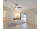 Bright living room with tile floors, fan, neutral walls, sliding doors opening to screened lanai and a pool at 3128 Ibis Hill St, Clermont, FL 34714