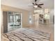 Bright living room boasts tile flooring, fan, neutral walls, and large sliding doors to screened in lanai at 3128 Ibis Hill St, Clermont, FL 34714