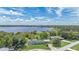 An aerial view of a single Gathering home with a manicured front lawn and lake views and a metal roof at 31636 Gladys Ln, Tavares, FL 32778