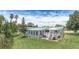 A manicured lawn, mature trees, gazebo, screened in patio and a deck grace this backyard at 31636 Gladys Ln, Tavares, FL 32778