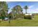 Picturesque backyard featuring a pond, dock, shed, lush lawn, and mature trees, ideal for relaxation at 31636 Gladys Ln, Tavares, FL 32778