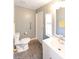 Bright bathroom featuring a modern vanity, toilet, grey stone flooring, and hand rails at 31636 Gladys Ln, Tavares, FL 32778