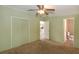 Bright bedroom with green walls, ceiling fan, and open doors leading to the kitchen and bathroom at 31636 Gladys Ln, Tavares, FL 32778