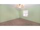 Simple bedroom featuring green walls, a ceiling fan and neutral carpeting for a cozy atmosphere at 31636 Gladys Ln, Tavares, FL 32778