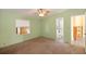 Spacious bedroom with a ceiling fan, carpeted floors, and views of the bathroom and outside at 31636 Gladys Ln, Tavares, FL 32778