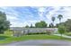 Charming home with a metal roof, carport, and lush landscaping near a tranquil lake at 31636 Gladys Ln, Tavares, FL 32778