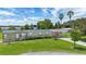Charming home with a carport, lush landscaping, and a metal roof, near a tranquil lake at 31636 Gladys Ln, Tavares, FL 32778