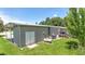 Exterior of home featuring storage shed, propane tank, and a grassy backyard at 31636 Gladys Ln, Tavares, FL 32778