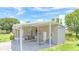 Exterior of home featuring covered parking, lush lawn, and mature landscaping at 31636 Gladys Ln, Tavares, FL 32778