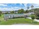 Charming home with a metal roof, carport, and lush landscaping near a tranquil lake at 31636 Gladys Ln, Tavares, FL 32778
