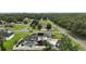Aerial view of house showing screened in pool, patio, fenced yard, mature trees and solar panels at 318 Stone Castle Loop, Lady Lake, FL 32159
