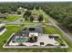 Aerial view showcases a fenced yard, screened pool, patio, trampoline, landscaping and solar panels at 318 Stone Castle Loop, Lady Lake, FL 32159